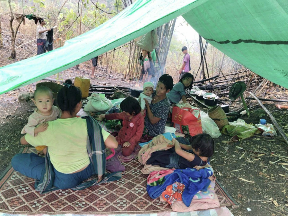 Displaced people under tarpaulin